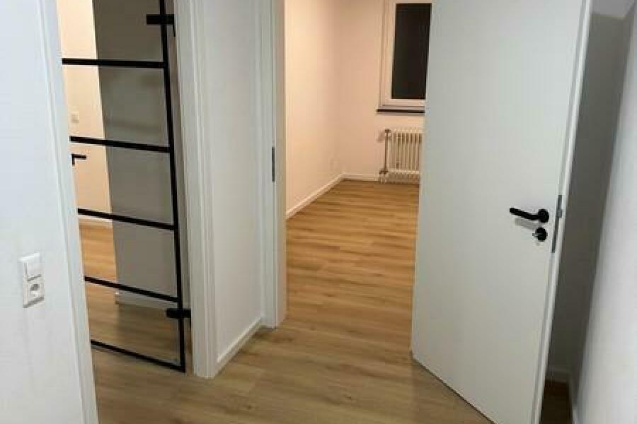 6 Flur Blick in Richtung Küche und links WoZi mit Glastür